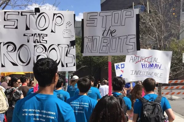 Picture of protestors with "Stop the Robots" signs